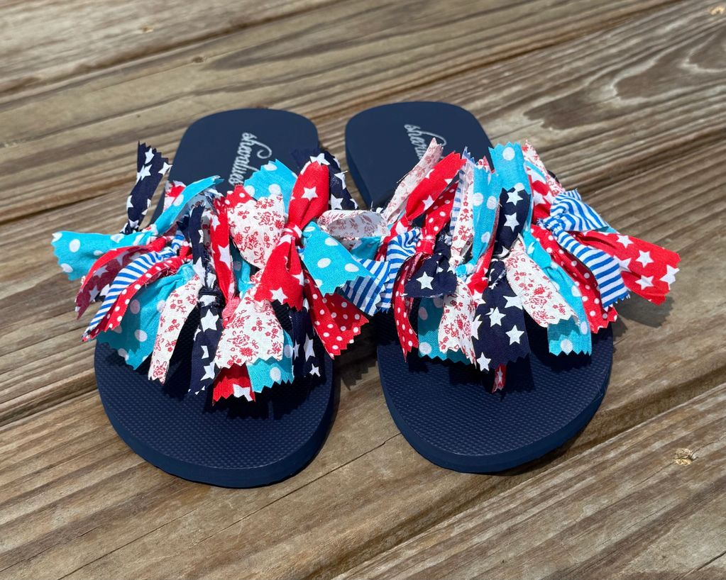 Colorful flip-flops with red, white, and blue fabric decorations.