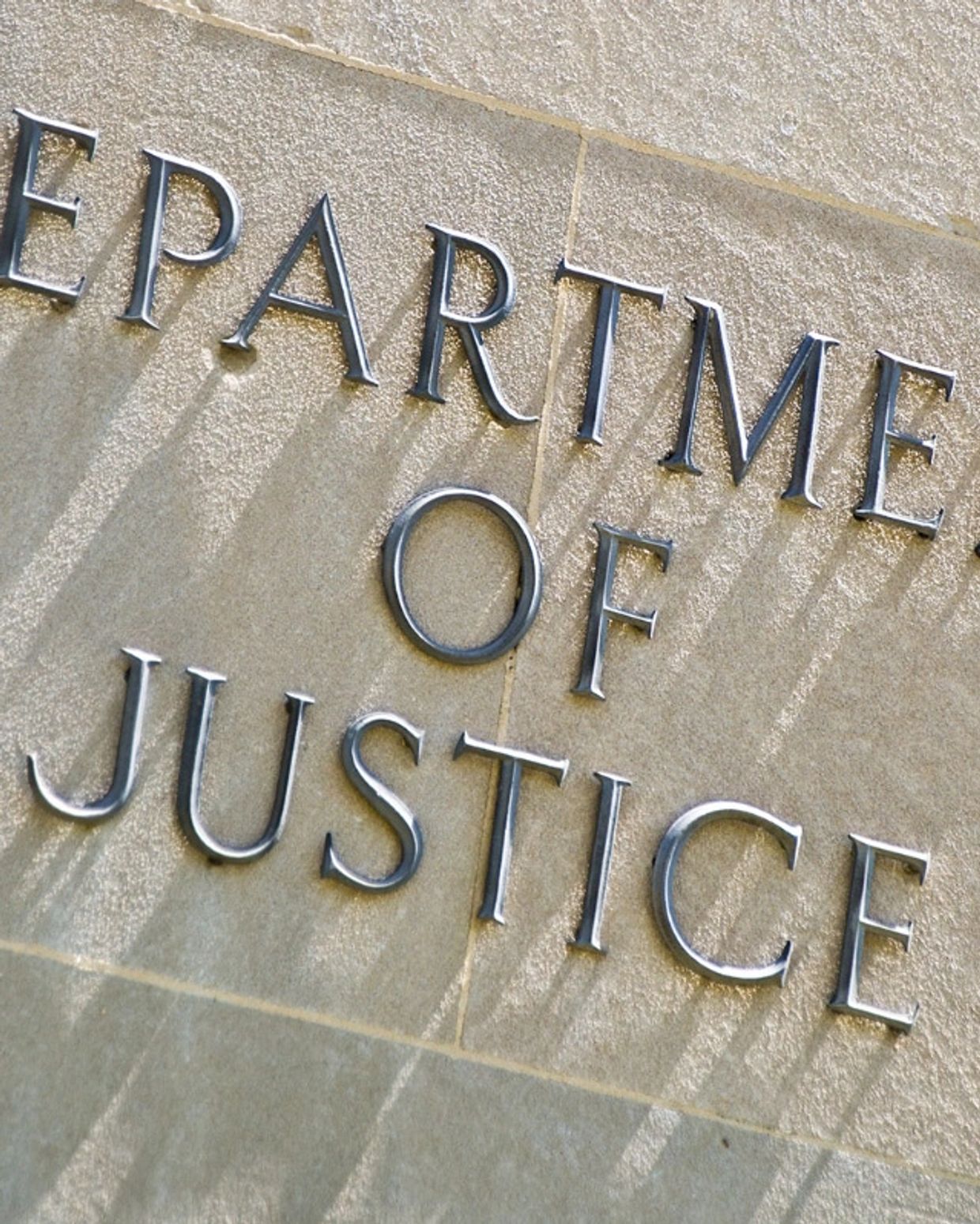 Close-up of Department of Justice building sign with shadows.
