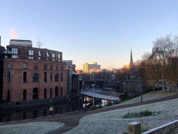 Castle Park in Bristol. Frost is visible on the grass and you can see a church spire and the river.