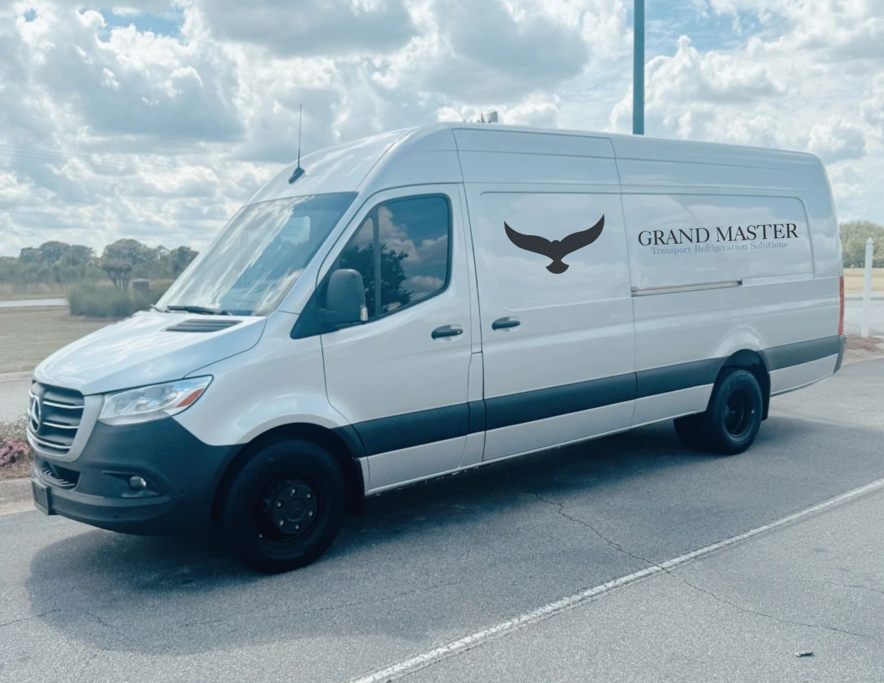 White delivery van with Grand Master logo on the side.