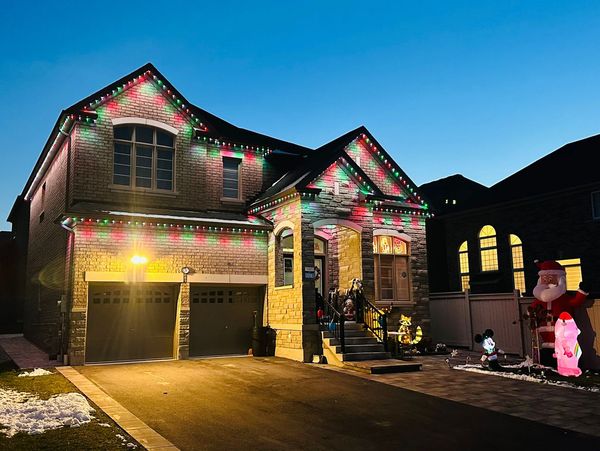 Georgina home with permanent Christmas lights glowing in red and green during the evening.