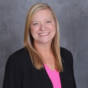Smiling woman with blonde hair in business attire.