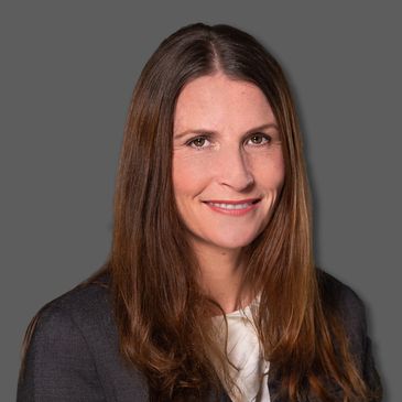 Professional woman with long brown hair smiles.
