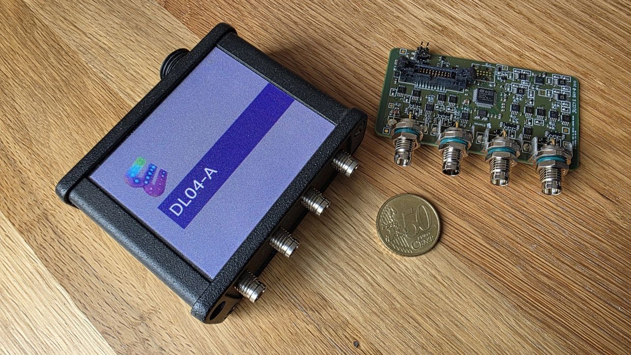 DL04-A electronic device and circuit board with 50 cent coin on wooden surface.