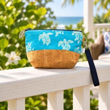 Blue floral pouch with cork bottom on a white railing.
