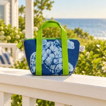 Blue and green floral handbag on a white porch railing.