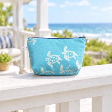 Blue pouch with white turtles by the beach.
