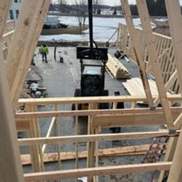 Construction site with wooden framing and workers near a tractor.