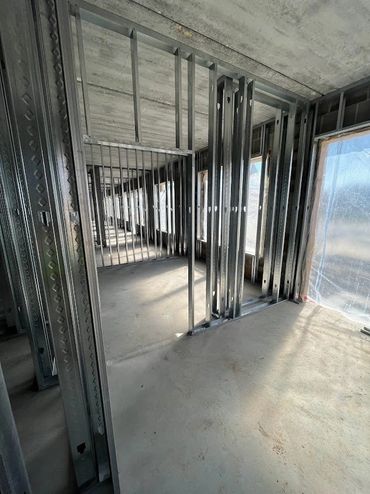 Interior of a building under construction with steel framing and concrete floor.