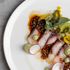 Dish of hamachi with salsa macha, avocado and spruce crema, radish salad and sea grapes