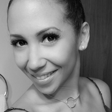 Close-up black and white portrait of a smiling woman.