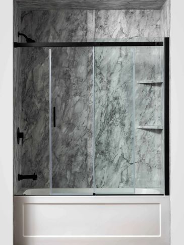 Modern bathroom with marble walls and glass shower enclosure.