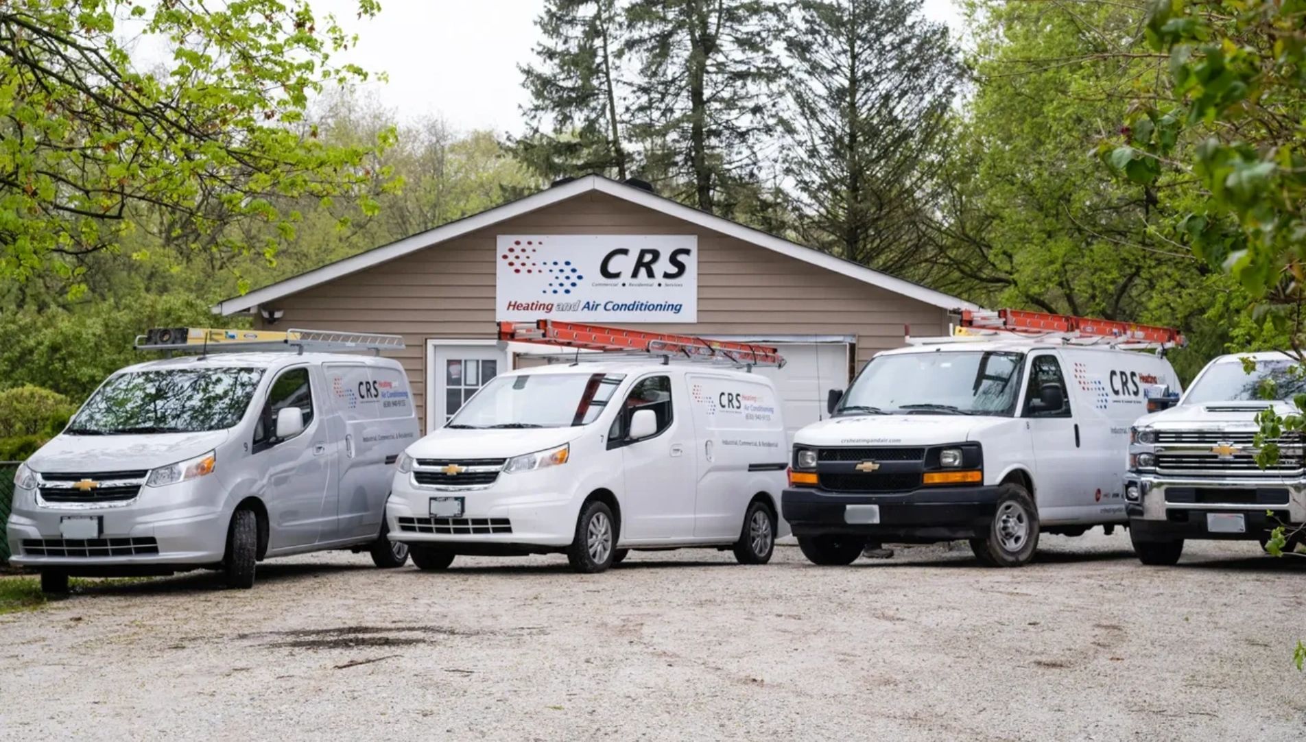 CRS Heating and Air Conditioning service vans parked outside company building in McHenry.