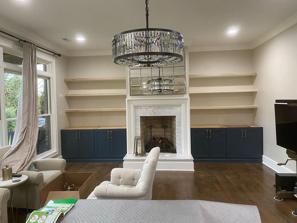 Modern living room with fireplace and empty shelves.