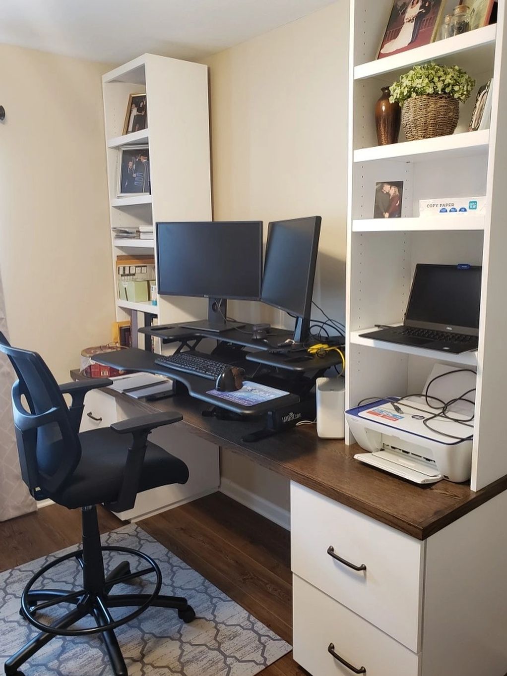 A modern home office setup with dual monitors and a printer.