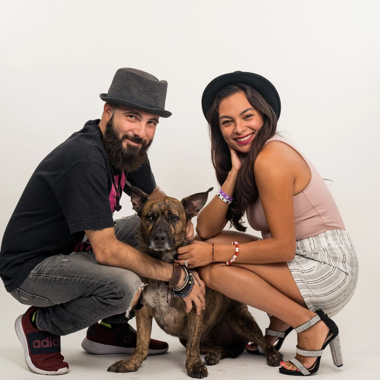 Latino man with Latina Woman kneeling by their dog 