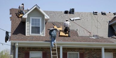 roof replacement job in progress with several men working on roof