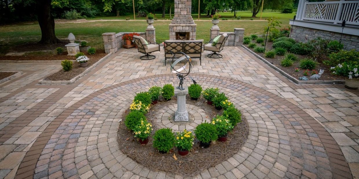 Concrete Paver patio design with outdoor fireplace and statue. 