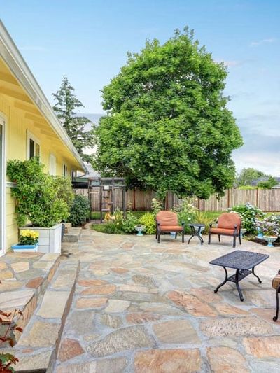 Beautiful natural stone patio with blooming landscape on a bright Spring afternoon. 