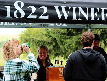 People enjoying wine tasting at 1822 Winery outdoors.