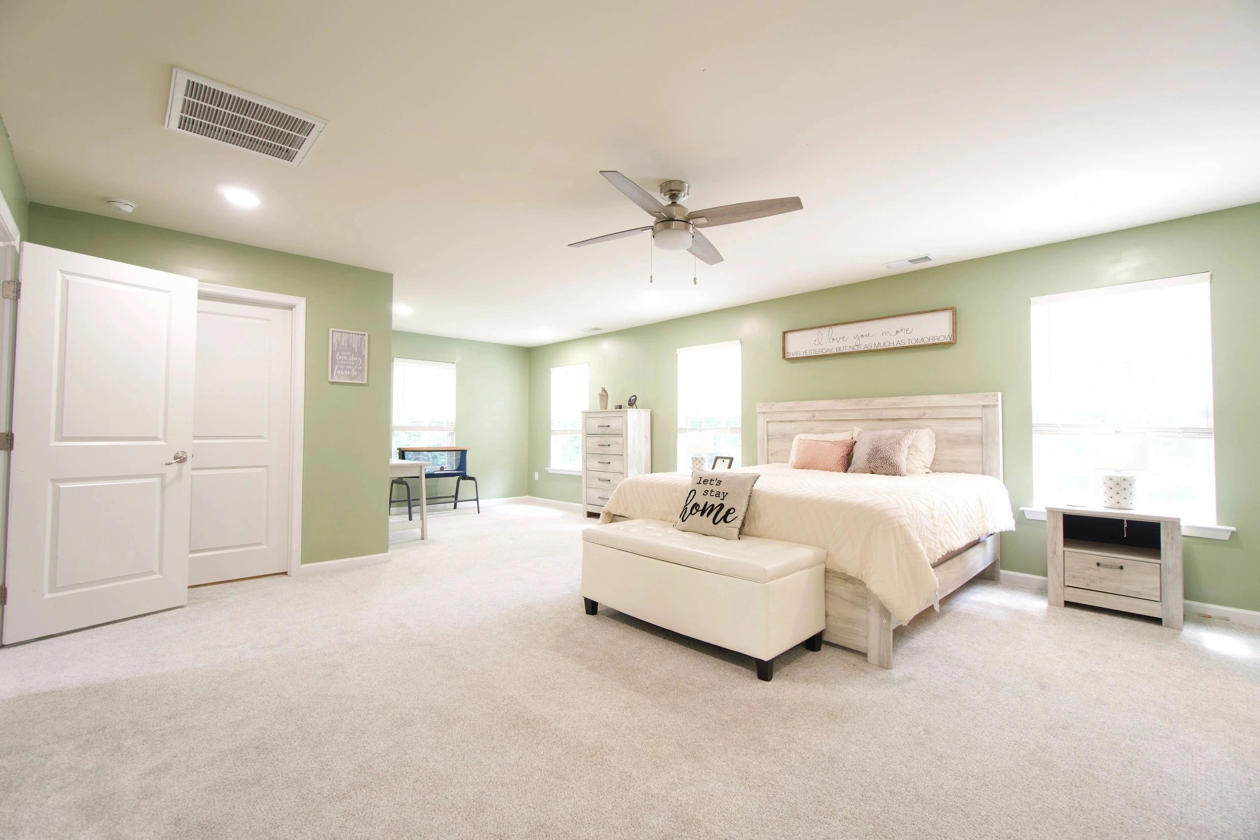 Bright, spacious bedroom with green walls and modern furnishings.