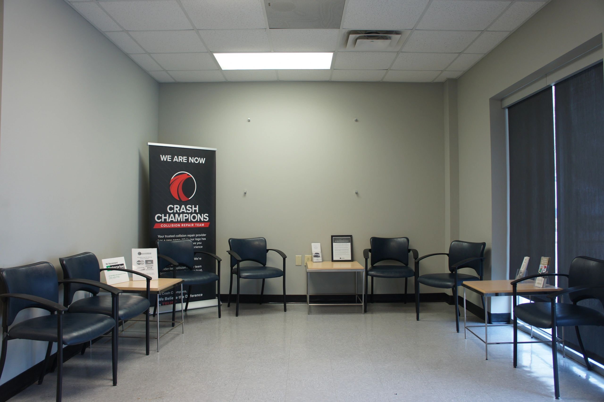 Waiting room with blue chairs and Crash Champions banner.