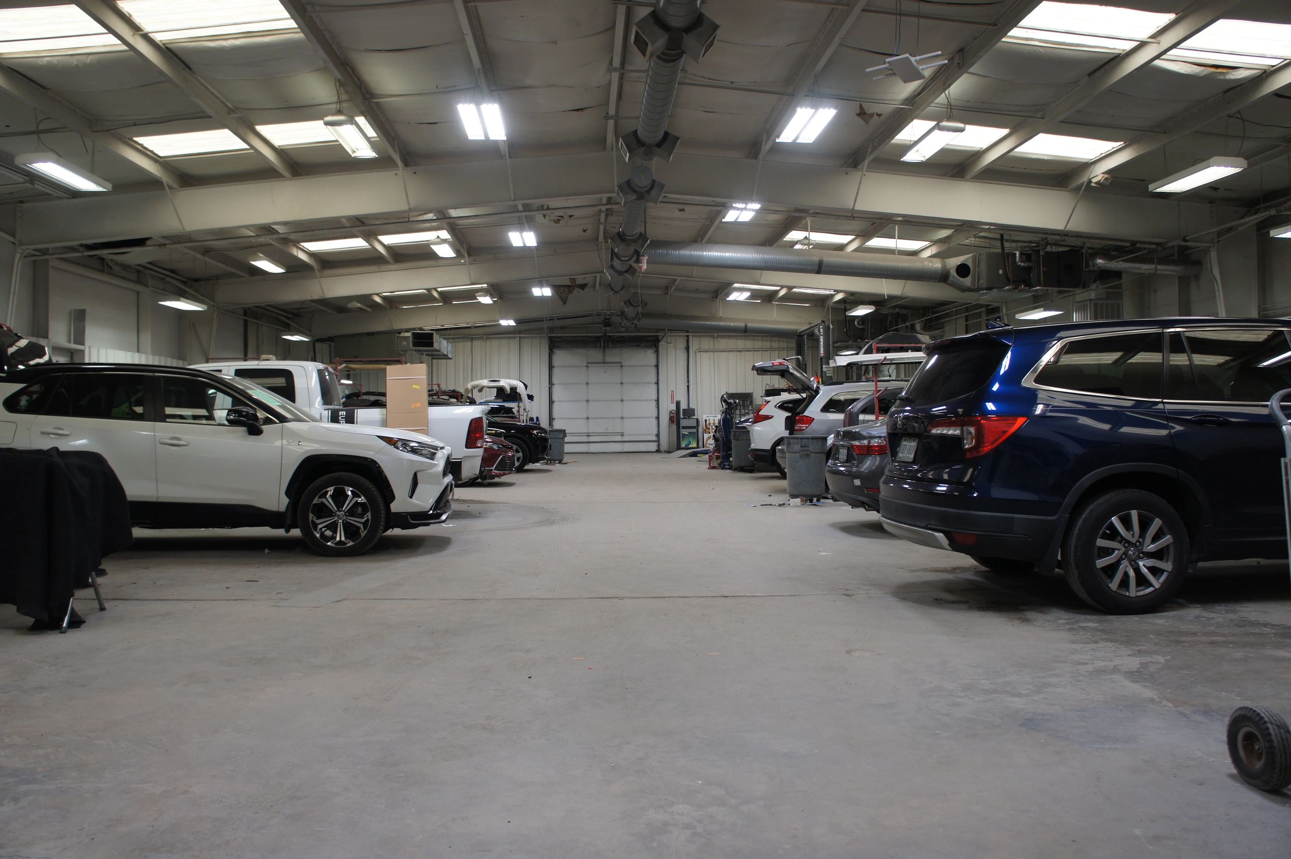 Interior of a spacious garage with several vehicles parked inside.
