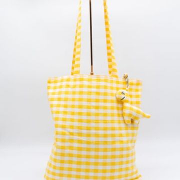 Yellow and white checkered tote bag with a small plush toy keychain.