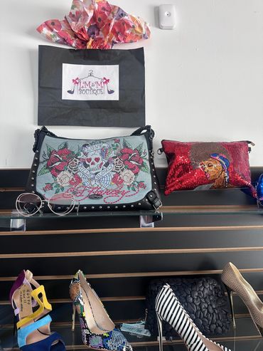 Display of colorful handbags and shoes in a boutique.