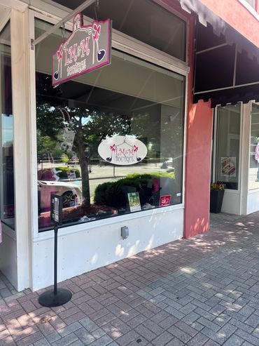 Storefront of a boutique named "Kimmy Boutique" with signage and display windows.
