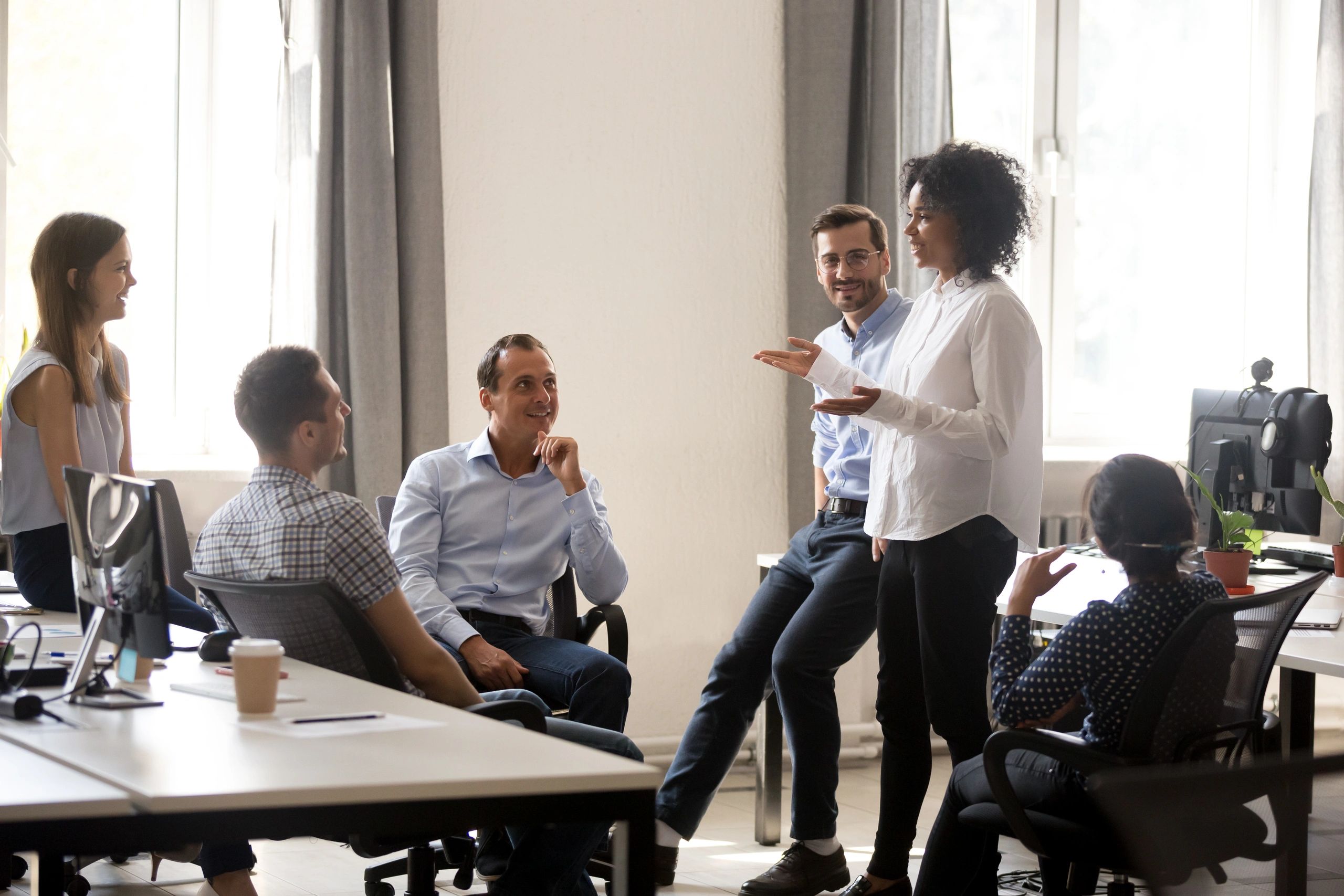Women in office talking to team