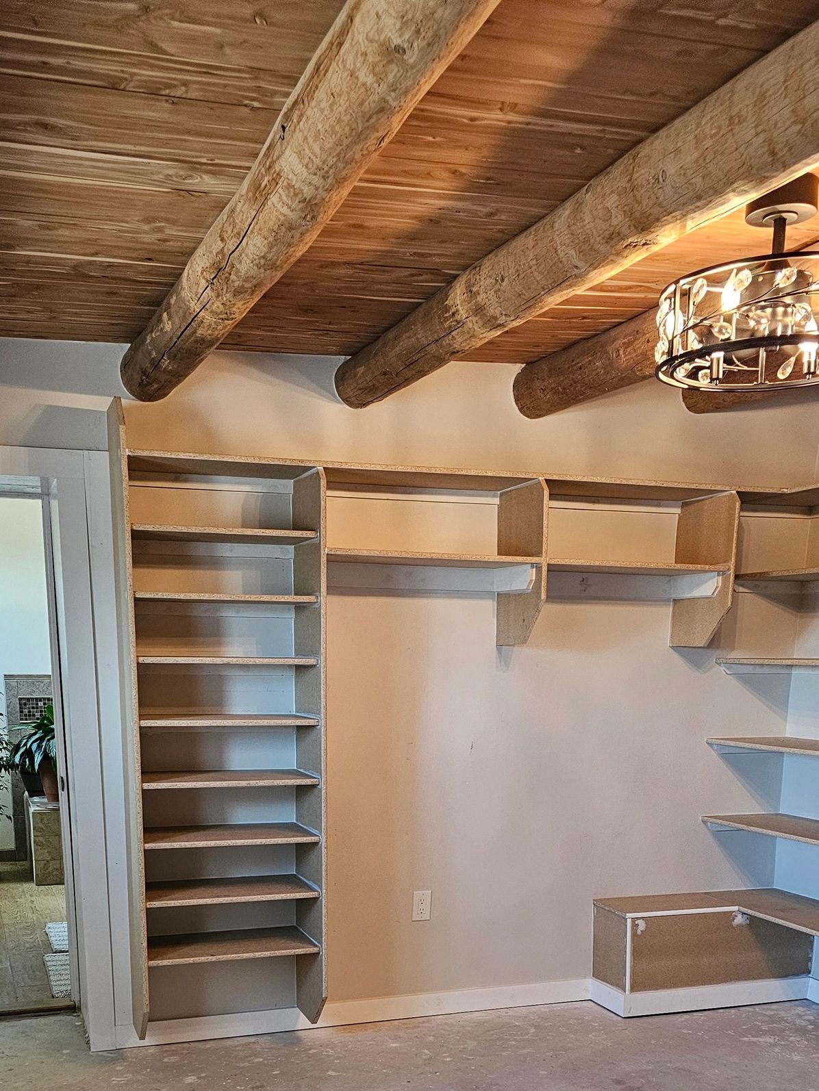 Empty closet with wooden beams and shelves.
