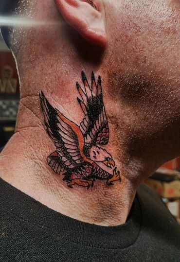 Flying bird tattoo on side of neck.