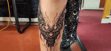 Intricate symmetrical moth neck tattoo.