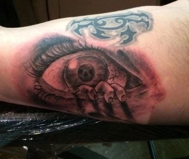 Giant eye and cloud scene tattoo.
