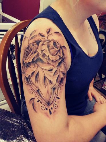 Large rose and heart shoulder tattoo.