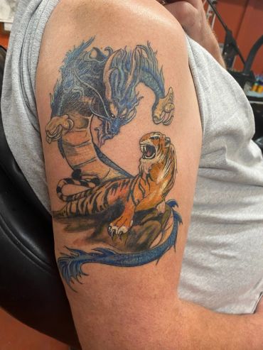 Bird and dragon bicep tattoo.