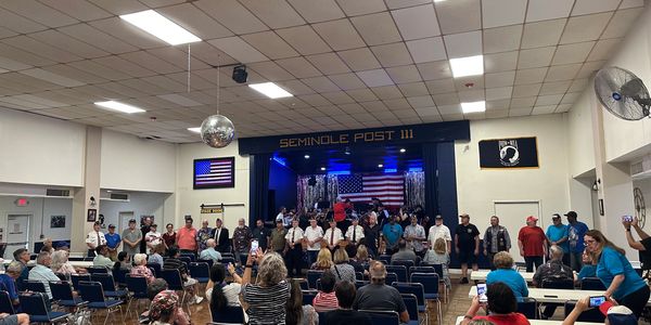 A meeting in the Seminole Post 111 main event with over 50 people seated for a legion ceremony