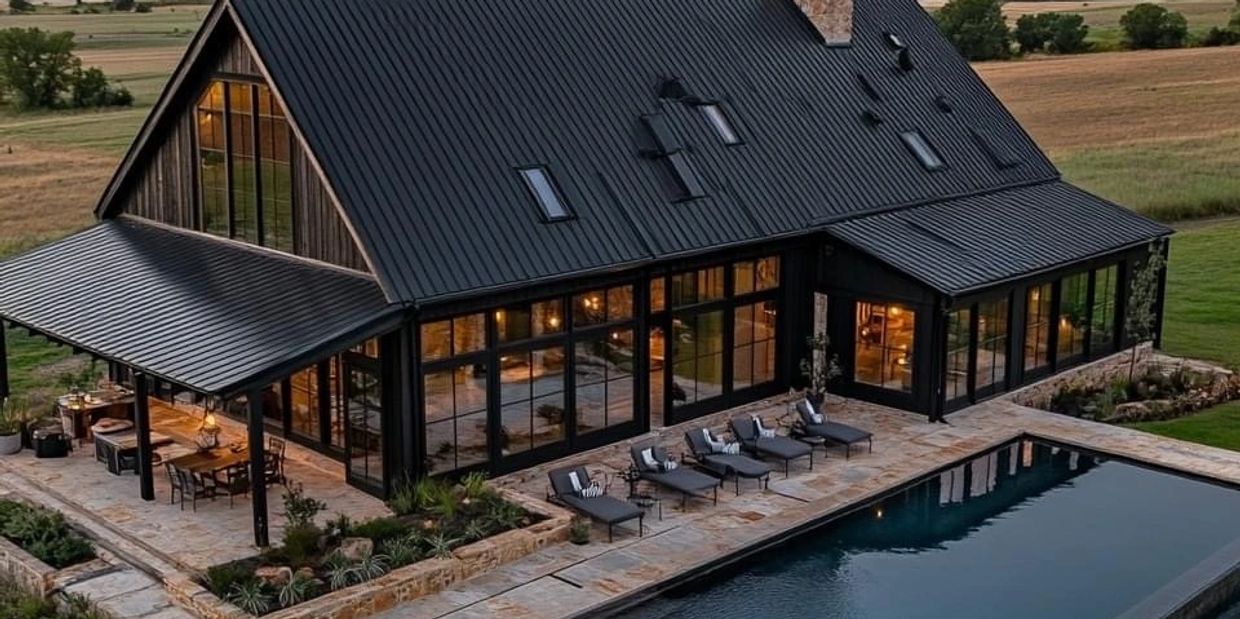 Modern black house with large windows and a poolside patio with loungers.