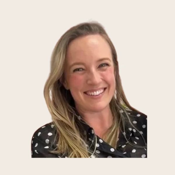 Blonde woman in a polka-dot dress smiling. 