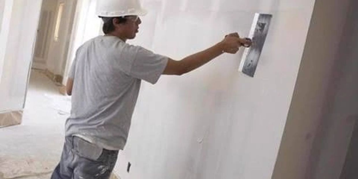 Applying mud to wall using 12 inch blade
