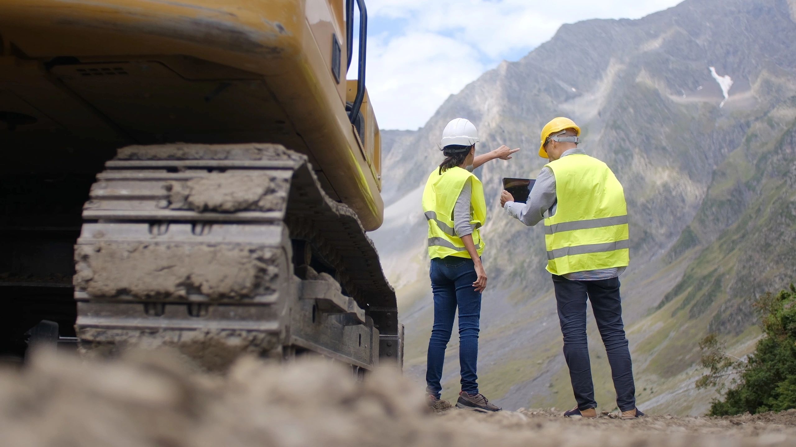 Dos trabajadores en un sitio de construcción en la montaña.