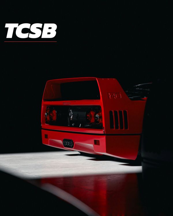Rear view of a red sports car with TCSB logo.