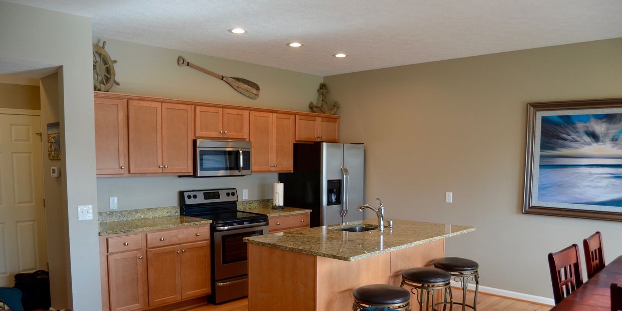 Modern kitchen with wooden cabinets and granite countertops.