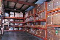 Warehouse shelves filled with stacked cardboard boxes.