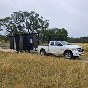 Tiny home being towed by Dodge Ram, setup of tiny home was also completed.