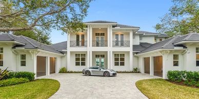 Luxurious two-story house with a driveway and a car.