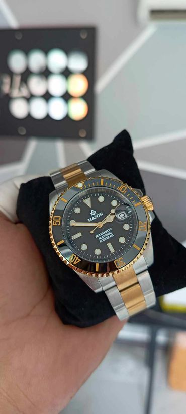 A luxury two-tone wristwatch with black dial and gold accents.