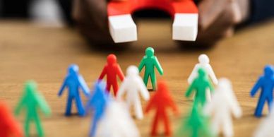 Hands holding a magnet towards plastic figures