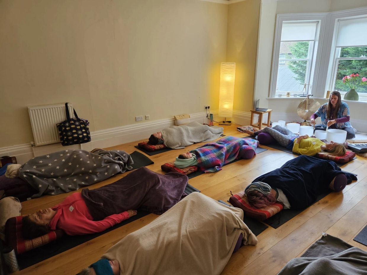 People in a sound healing meditation session with crystal bowls.